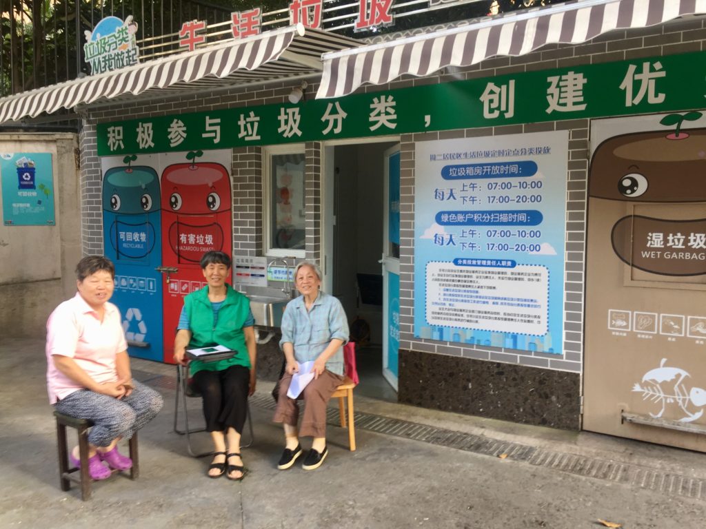 Text Box: Figure 6: A volunteer and her friends catch up with each other while waiting for their neighbours to bring their recycling